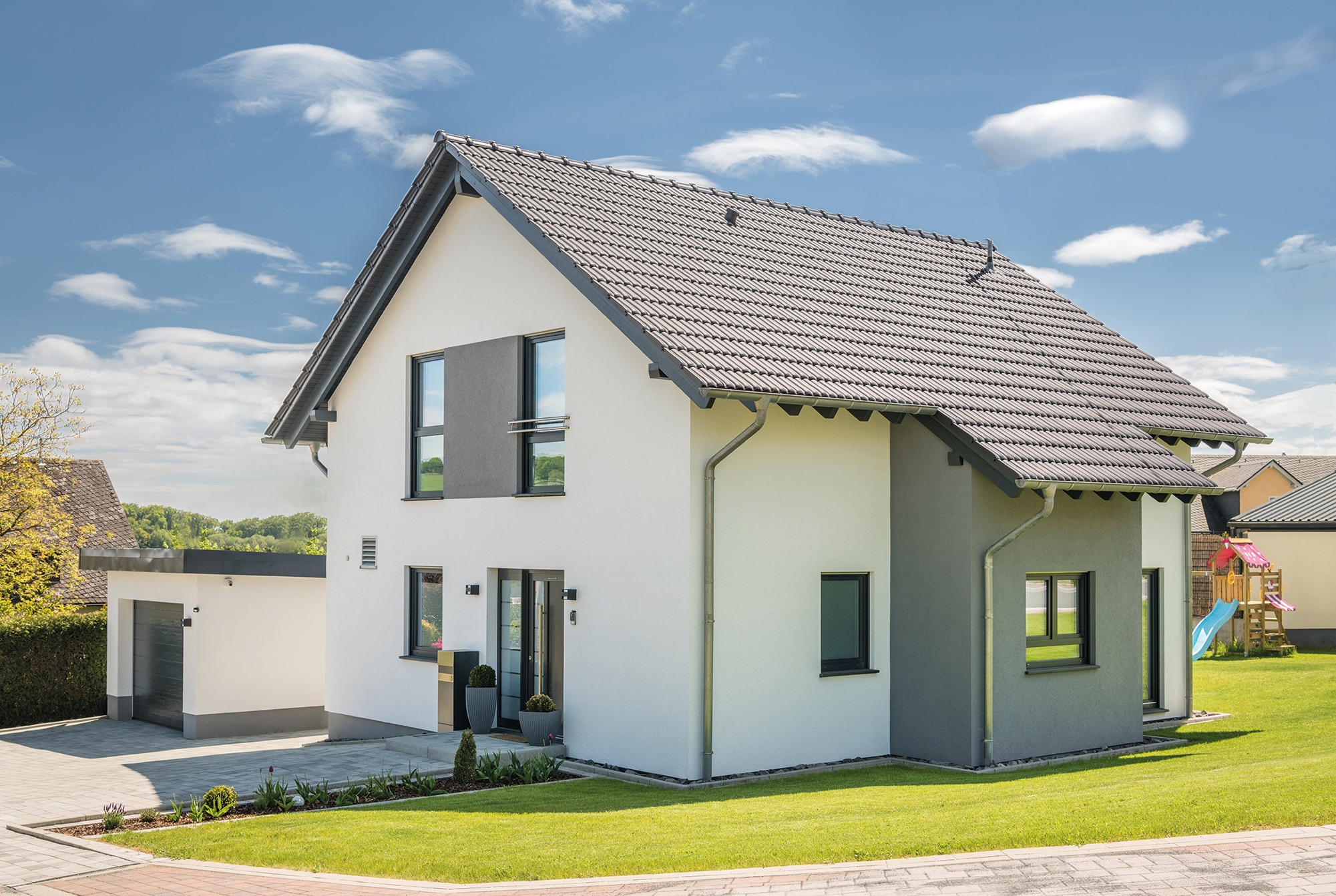 Familie baut mit Fingerhut Haus auf Wohngesundheit im modernen Satteldachhaus
